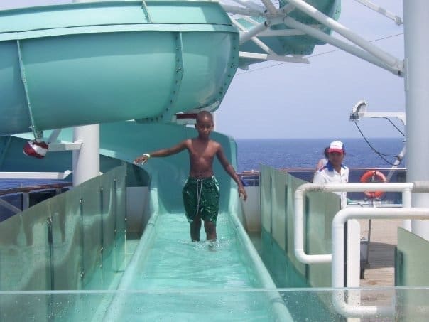 Child playing on a waterslide aboard a cruise ship, experiencing fun activities on a stress-free family vacation.