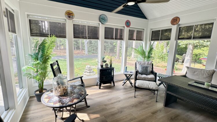 Bright sunroom sanctuary with rocking chairs, plants, and views of nature, designed as a Mindful Tranquil Home Oasis retreat space