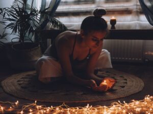 Woman holding a candle during quiet meditation ritual at home