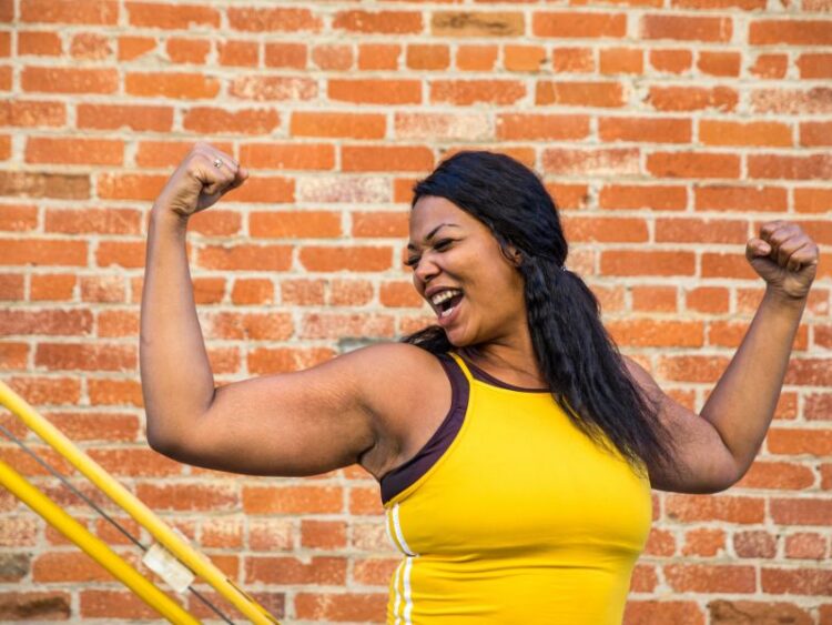 Confident woman celebrating strength and progress through incremental self-care changes.