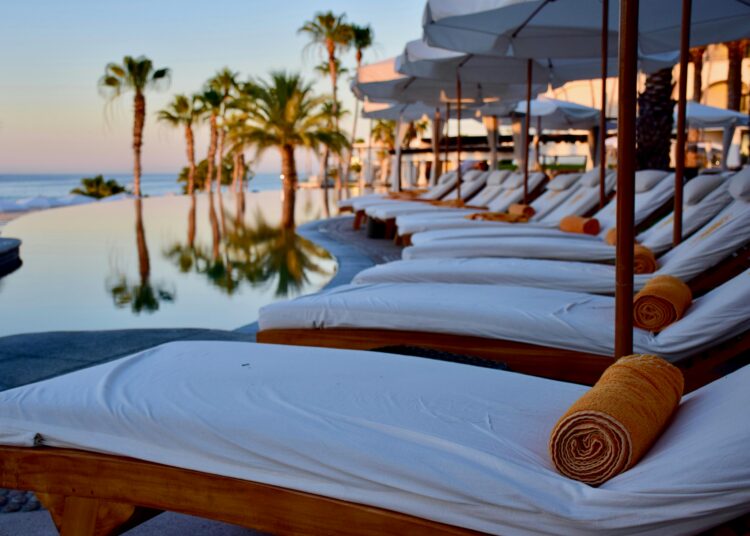 Wellness travel retreat with poolside lounge chairs and ocean view