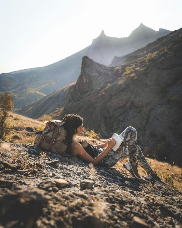 pexels-photo-9021474-9021474 A woman enjoys a tranquil moment journaling in the picturesque mountains of Russian Krasnodar region.
