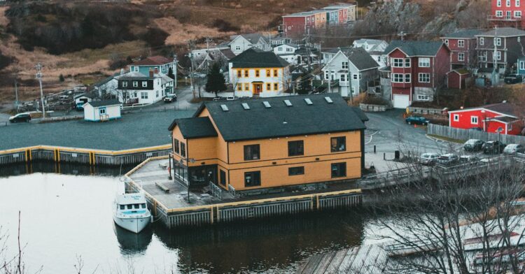 A serene sunset over St. John’s harbor, showcasing colorful houses and calm waters, perfect for digital detox travel.