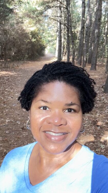 woman practicing mindful living during a nature walk on a wooded trail