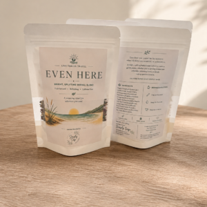 Front and back of Even Here Herbal Tea by Live Thrive Travel, a bright, uplifting caffeine-free herbal tea included in the Signature First Night Gift.