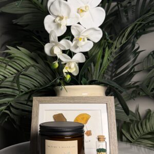 Nature's Scent Co. Sea Salt & Orchid beeswax candle with decorative green-tipped matches styled as part of the First Night Gift Collection.