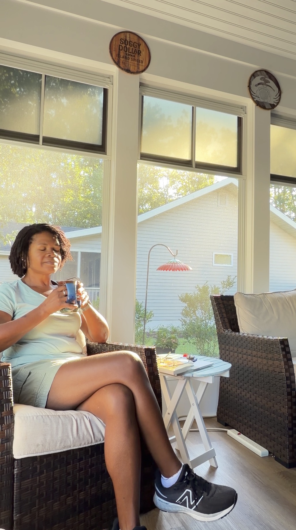 Woman sitting by a sunny window holding a warm cup of tea during a quiet evening ritual