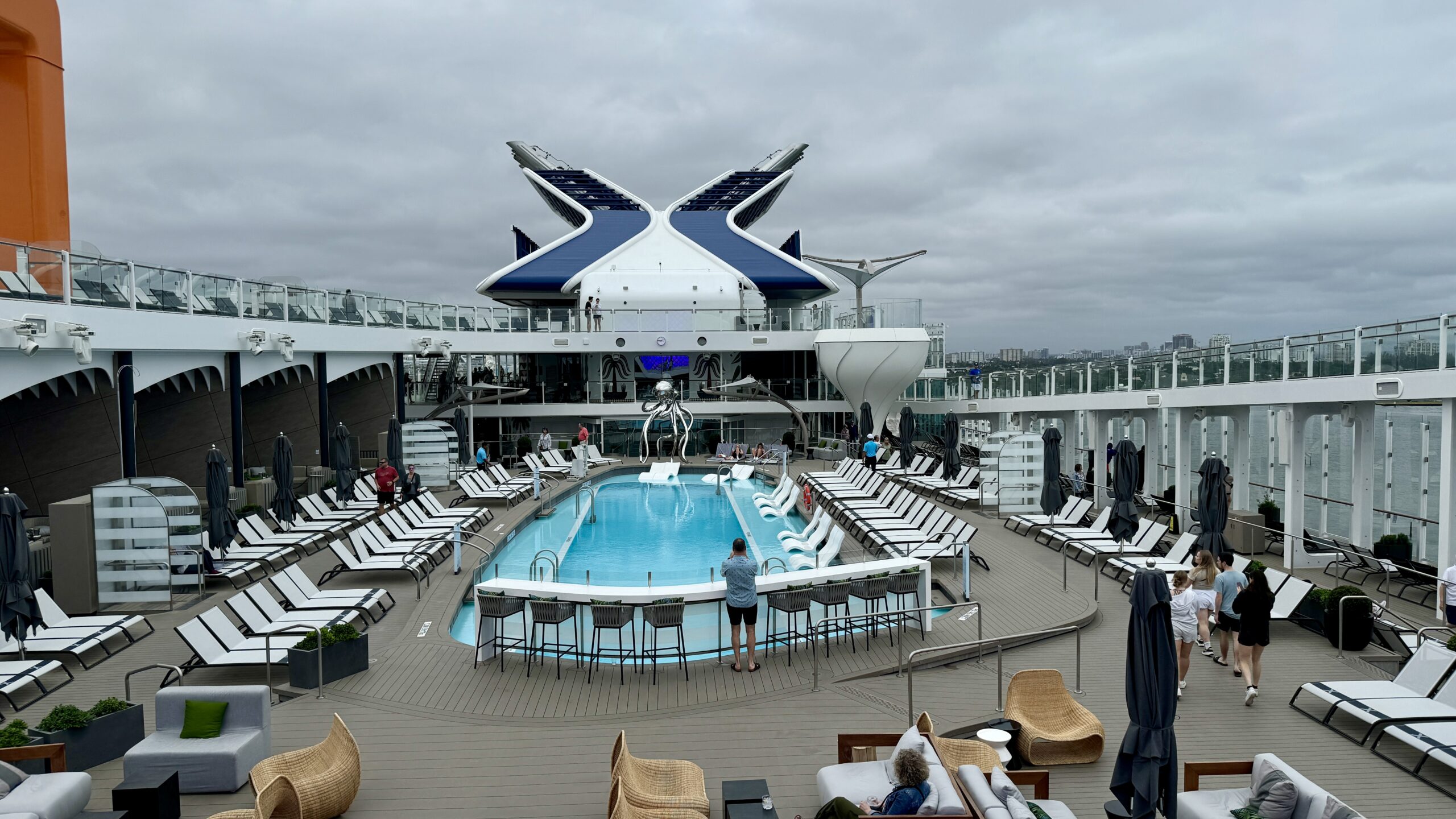 Pool and lounge chairs on the open deck of Celebrity Ascent