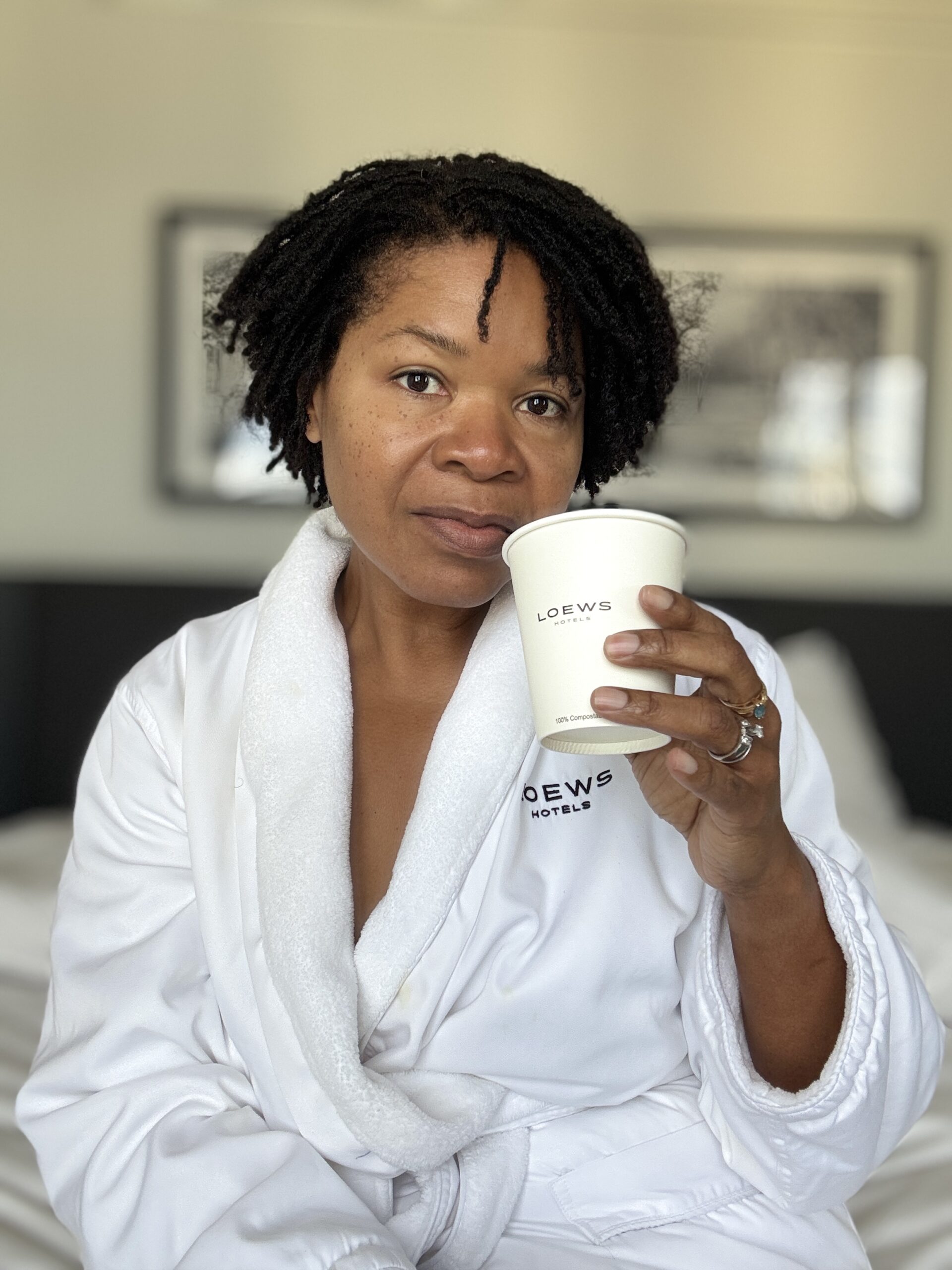 Subrinia holding a cup while seated in her room at Loews Philadelphia